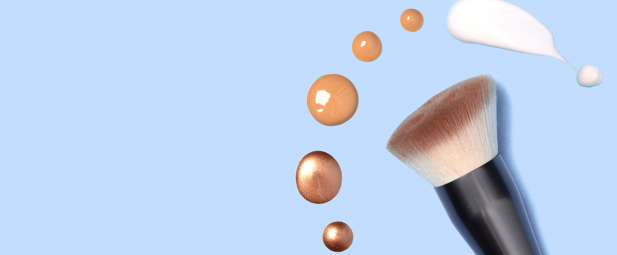 Custom Application Brush next to drops of foundation, moisturizer, and enhancer drops